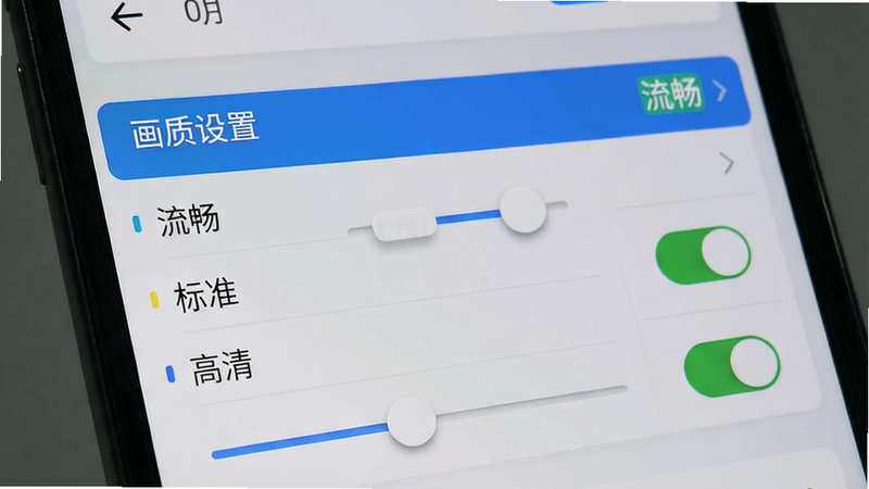 主体为手机屏幕截图,显示游戏设置界面,其中“画质设置”选项被高亮选中,下方有“流畅”、“标准”、“高清”三个选项,当前选中“流畅”。布局为列表式菜单,字体清晰。风格为简约UI,背景为浅灰色。细节包括滑块控件、开关按钮的状态指示。画质清晰,无多余水印,文字可读性强。