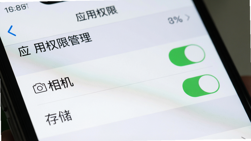一张手机设置界面的特写图,显示“应用权限管理”页面,高亮显示“相机”和“存储”权限开关,背景模糊处理,突出操作重点,风格写实,细节清晰,画质高,干净,无多余元素