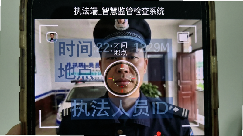 主体为手机拍摄界面特写,显示“执法端_智慧监管检查系统”正在录制视频,画面中叠加了半透明的蓝色水印框,包含“时间”、“地点”、“执法人员ID”字样,布局紧凑,风格写实,细节展现摄像头对焦状态,画质清晰,无杂色