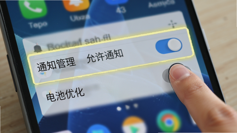 展示安卓手机系统设置界面的示意图,重点高亮显示“通知管理”和“电池优化”选项。画面中有一个手指图标正在点击“允许通知”的开关,背景为模糊的手机桌面,突出操作重点。风格写实,光影自然,细节清晰,无多余文字干扰。