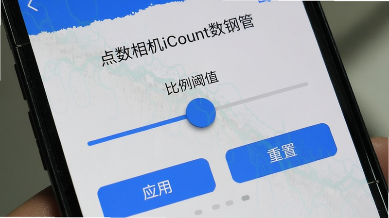 手机屏幕特写,显示'点数相机iCount数钢管'的校准界面,中间有一个滑动条用于调整'比例阈值',下方有'应用'和'重置'按钮,界面简洁,蓝色高亮,清晰展示操作细节,无其他干扰信息