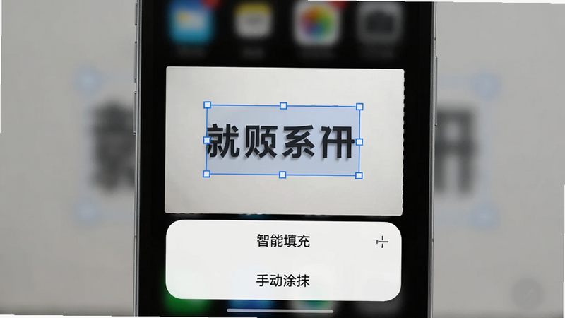手机界面截图,主体为应用操作界面,中央显示一张包含文字的照片,文字区域被蓝色选框选中,下方弹出“智能填充”、“手动涂抹”选项,背景模糊处理,突出前景操作,风格科技简约,画质清晰,无水印