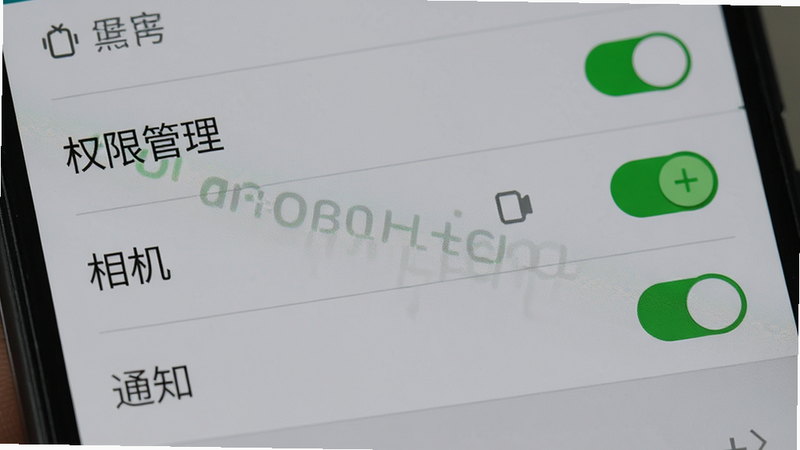 主体为手机设置界面特写,重点高亮显示“权限管理”中的“相机”和“通知”选项为开启状态,布局为典型的安卓设置列表风格,排版简洁,风格为中性科技灰,细节展示开关按钮的绿色状态,画质清晰,干净,无多余元素