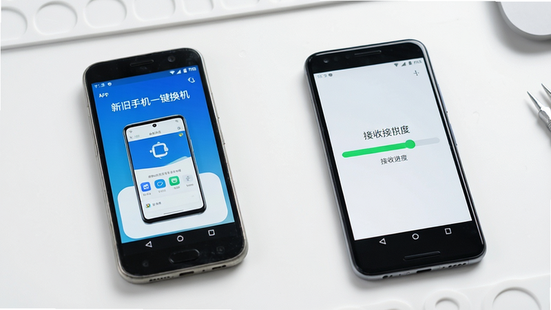 主体为两部安卓手机,左侧旧手机屏幕显示“新旧手机一键换机”App界面,右侧新手机屏幕显示数据接收进度条,背景为简洁的白色工作台,风格现代简约,细节清晰,画质高清,干净无多余元素