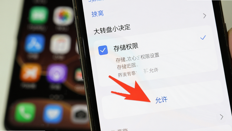 大转盘小决定手机端权限设置界面教程图,手机屏幕显示系统设置页,勾选“存储权限”,下方有红色箭头指向“允许”按钮,背景为模糊的手机桌面,突出关键操作步骤,实拍风格,光线明亮,文字清晰