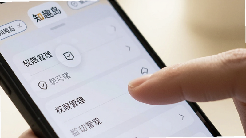 手机屏幕特写,显示知趣岛应用设置页面,手指正在点击'权限管理'选项,界面清晰,光线柔和,背景虚化,突出操作细节