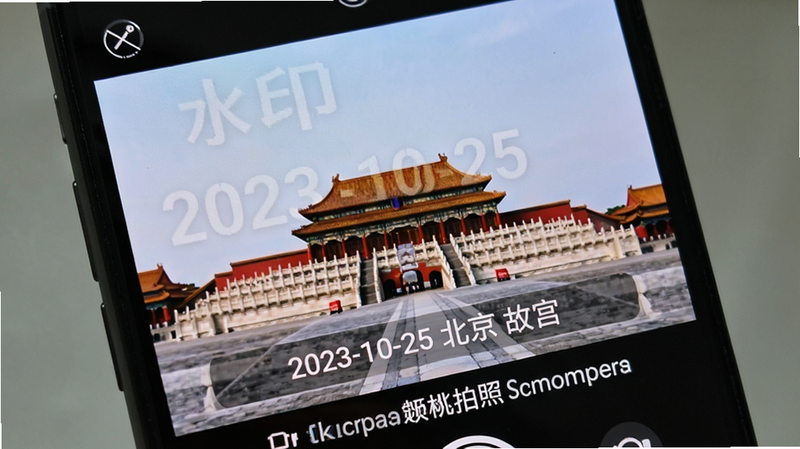 手机屏幕特写,显示“水印定位相机拍照”App正在拍摄一张风景照,照片上叠加了半透明水印,包含“2023-10-25 北京 故宫”字样,布局居中偏下,排版整齐,风格写实,细节清晰,画质高,无水印干扰