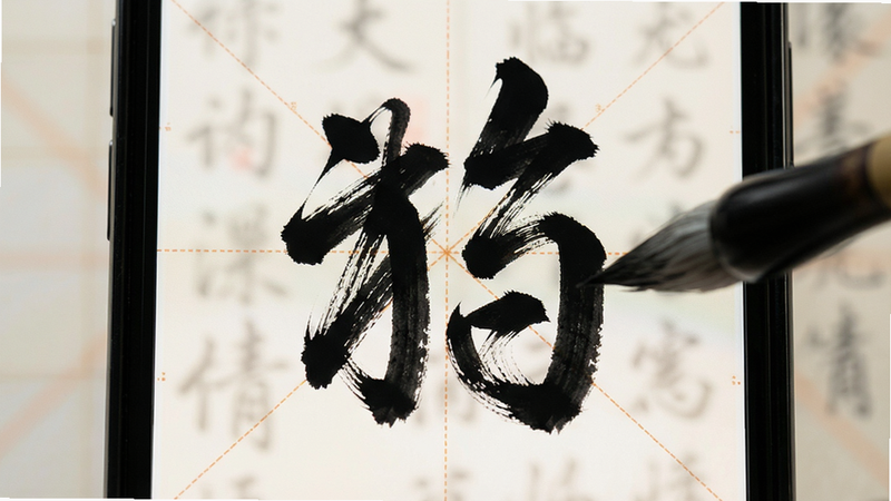 主体为手机屏幕显示临摹界面,背景为半透明米字格,前景为黑色毛笔字迹,布局聚焦中心,排版对称,风格专业,细节展现笔触质感,画质高清,干净无多余元素