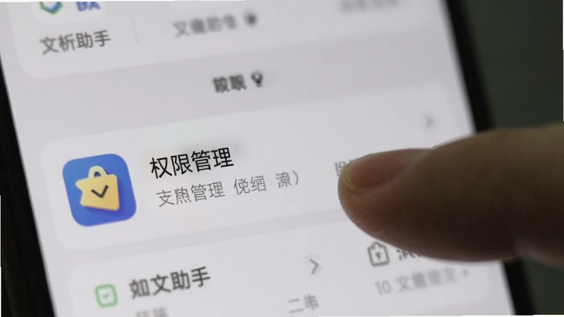 手机设置界面截图,突出显示“权限管理”选项,手指点击“文析助手”应用,背景模糊,焦点清晰,风格写实