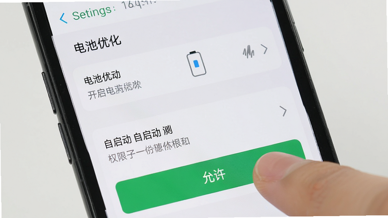 展示手机设置界面中开启“电池优化”与“自启动”权限的截图,手指正在点击“允许”按钮,界面清晰,重点突出权限设置区域,背景简洁,体现设置过程的简单易懂,高清细节