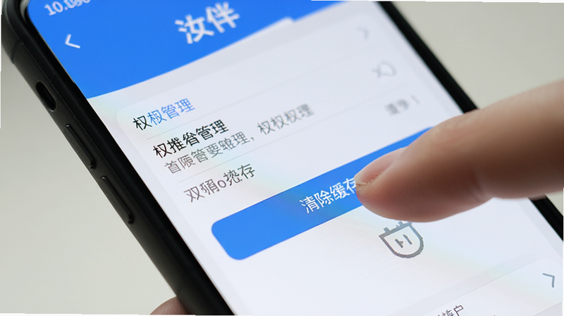 手机屏幕特写,显示汝伴APP的设置界面,突出显示权限管理部分,手指正在点击“清除缓存”按钮,界面清晰,光线柔和,强调操作细节,高清晰度