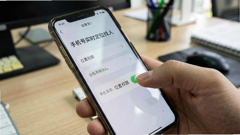 主体是一只手拿着手机,屏幕显示