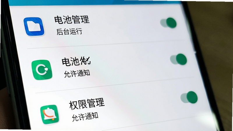 手机设置界面示意,主体为安卓系统设置菜单,布局展示应用管理、电池优化、权限管理选项,排版列表式,风格为系统原生UI,细节包含开关按钮、应用图标、文字“后台运行”、“允许通知”,画质清晰,干净,无多余元素,侧视角度,屏幕亮光