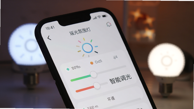 手机屏幕特写,显示“瑶光氛围灯”APP的调色滑块界面,背景为模糊的智能灯泡发光效果,UI设计简洁现代,文字“智能调光”清晰可见