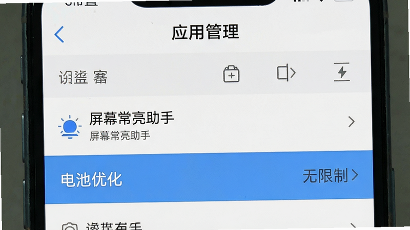 手机设置界面示意图,主体为“应用管理”页面中选中“屏幕常亮助手”,高亮显示“电池优化”选项设为“无限制”,布局列表式排版,风格系统原生UI细节清晰,画质干净无多余元素
