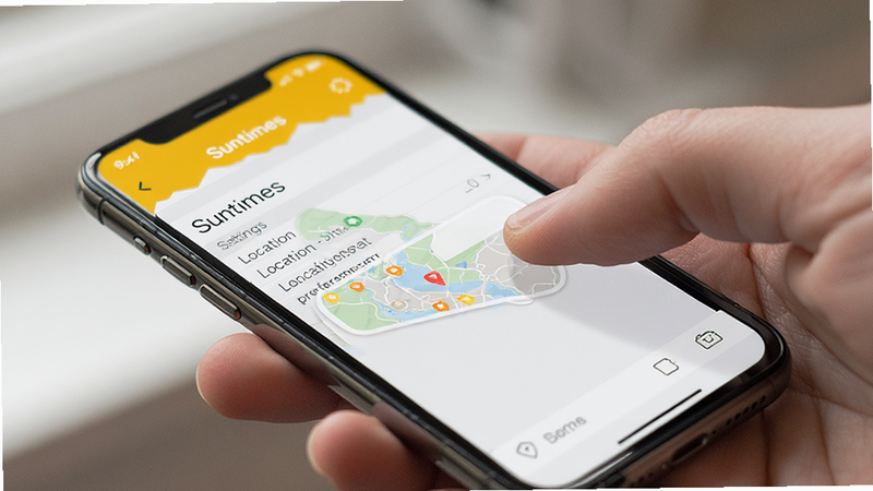 Smartphone displaying Suntimes app settings menu, user adjusting location preferences, clear UI elements, realistic device mockup