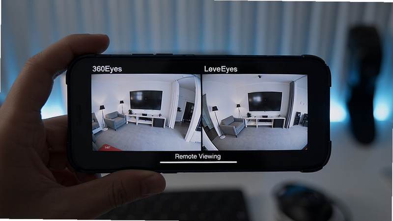 360Eyes remote viewing feature, smartphone displaying live camera feed, split screen view of two cameras, tech aesthetic, soft lighting