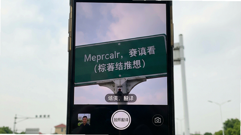 手机摄像头对准英文路牌,屏幕实时叠加中文翻译,界面底部有“拍照翻译”按钮,风格写实,画质清晰,无多余元素