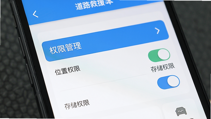 主体为手机屏幕显示道路救援app设置界面,其中“权限管理”选项高亮,布局整洁,风格扁平化,细节有“位置权限”、“存储权限”开关,画质清晰,无多余元素。