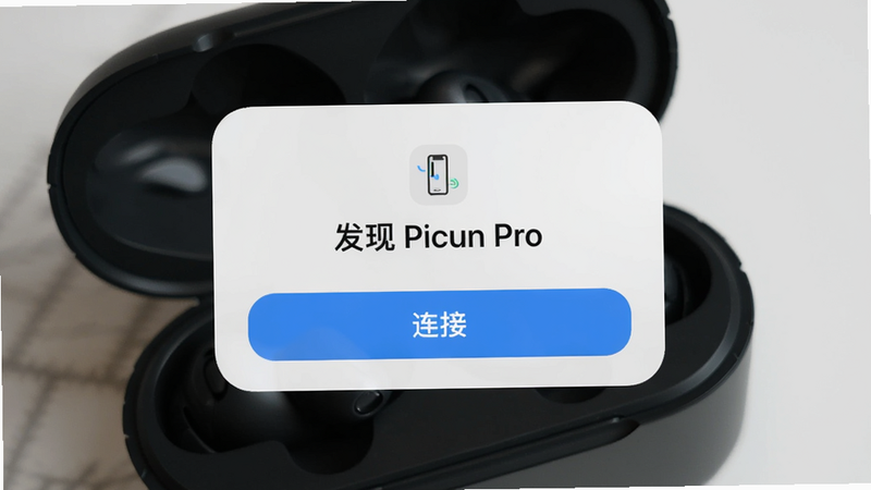 一张手机屏幕截图,显示 Picun APP 自动发现新设备的弹窗,弹窗上写着“发现 Picun Pro”,下方有“连接”按钮,背景是耳机充电仓开盖的实物图,构图居中,光影自然,画质高清。