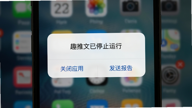 展示手机屏幕上的趣推文APP闪退提示界面,背景模糊,中间弹出“趣推文已停止运行”对话框,下方有“关闭应用”和“发送报告”按钮,整体风格简洁,画质清晰,无多余元素。
