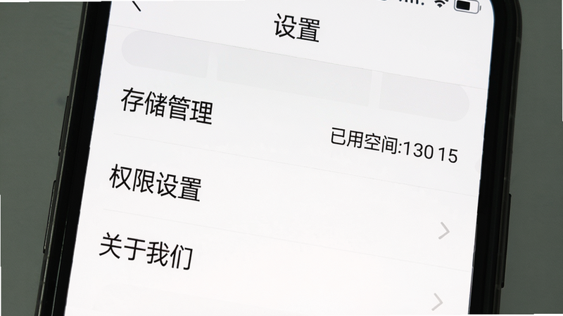 主体:手机屏幕上显示我好运APP设置界面,布局:顶部有“设置”标题,下方列表有“存储管理”“权限设置”“关于我们”等选项,排版:列表式,风格:简洁白底黑字,细节:存储管理旁显示已用空间,画质:清晰,干净无多余元素