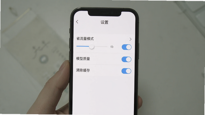 手机屏幕上显示国运奇经APP的“设置”界面,主体为竖屏,顶部有“设置”标题,中部依次排列“省流量模式”“模型质量”“清除缓存”等开关选项,背景为白色,排版整齐,风格简洁,细节包括滑块和箭头图标,画质清晰,无多余元素。