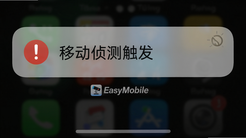 主体为手机锁屏界面弹出报警通知,通知横幅显示摄像机名称和“移动侦测触发”文字,布局居中,风格写实,细节通知图标为红色感叹号,背景暗色,画质干净,无多余元素,通知下方有“EasyMobile”标识。