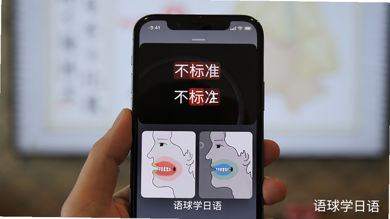 手机屏幕显示语音跟读结果,红色标注不标准音节,下方有舌位侧视图和