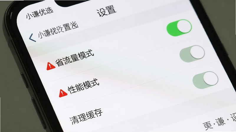 主体:手机屏幕展示“设置”界面,布局为列表式,包含“省流量模式”“性能模式”“清理缓存”等选项,风格为系统设置风格,背景白色,细节处有开关按钮和红色警告图标,画质清晰,图片中文字显示“小谦优选 设置”
