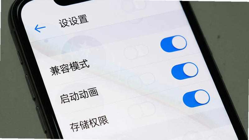 画面主体:手机屏幕展示宇宙工具箱“设置”页面,显示“兼容模式”、“启动动画”、“存储权限”等选项开关。布局列表式,顶部有返回箭头。风格:系统原生风格,清晰。细节:开关颜色为蓝色。画质:高清、无多余元素。