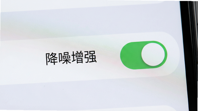 主体:手机屏幕显示设置界面,突出“降噪增强”开关,布局居中,风格扁平,细节:开关为绿色,背景浅灰,画质清晰,无多余元素