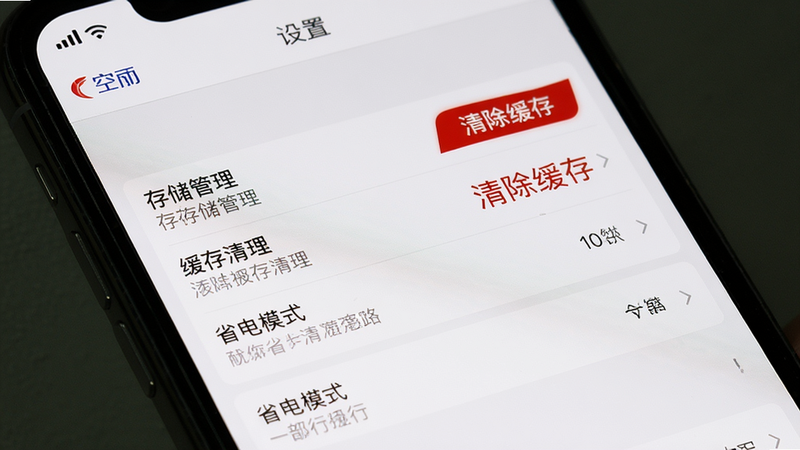 主体为手机屏幕显示空旅APP的“设置”页面,包含存储管理、缓存清理、省电模式等选项,列表清晰。布局为系统设置风格,背景白色,细节有红色“清除缓存”按钮和高亮提示文字,画质高清。