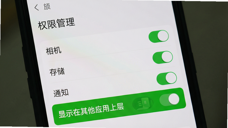 手机屏幕上显示蘑菇盒子APP的权限设置界面,列出相机、存储、通知等开关,其中“显示在其他应用上层”开关被高亮。背景是系统设置页面,风格简洁,画质高清,无多余元素。文字“权限管理”出现在顶部。