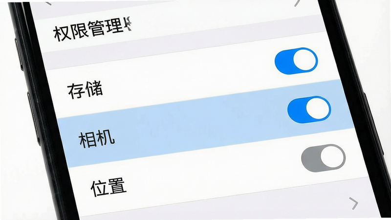 主体:一张手机截图显示美颜自拍App的权限设置界面,列表中有“存储”“相机”“位置”等选项,其中“存储”和“相机”已开启。布局:权限列表纵向排列,开关按钮在右侧。排版:文字清晰,开关颜色蓝灰。风格:系统原生风格,白色背景。细节:选中状态高亮。画质:高清,干净无多余元素。图片中文字“权限管理”。