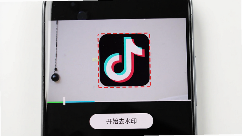 手机屏幕截图,显示去水印秀正在分析一段视频,视频画面中央有一个“抖音”水印被红色虚线框选中,界面下方有“开始去水印”按钮,手机边框圆润,背景为白色,画质清晰,色彩还原真实