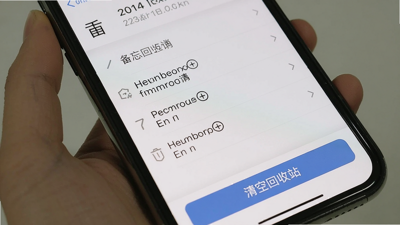 建议生图提示词:手机屏幕上显示备忘录(记事本笔记)的回收站界面,列表中有几条带删除样式的笔记,底部有“清空回收站”按钮,界面简洁,以白色为背景,画质清晰。
