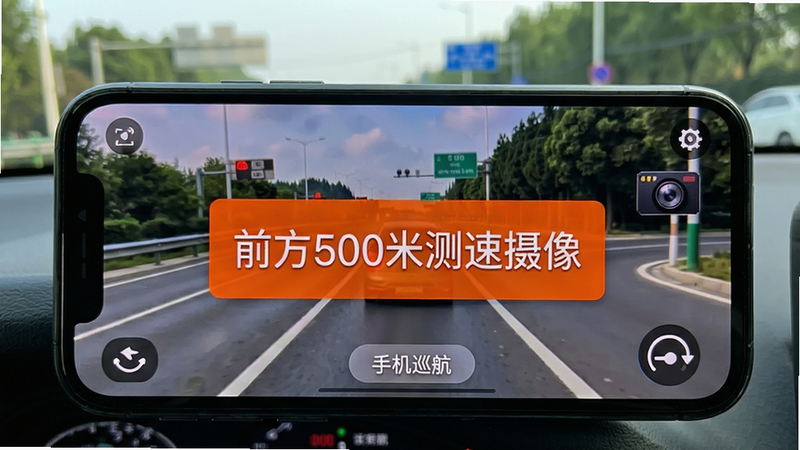 手机屏幕显示前方测速照相提醒的界面,橙色警示框内写着“前方500米测速摄像”,背景是道路实景图,界面风格清晰醒目,突出“手机巡航辅助导航”的预警功能,画质干净