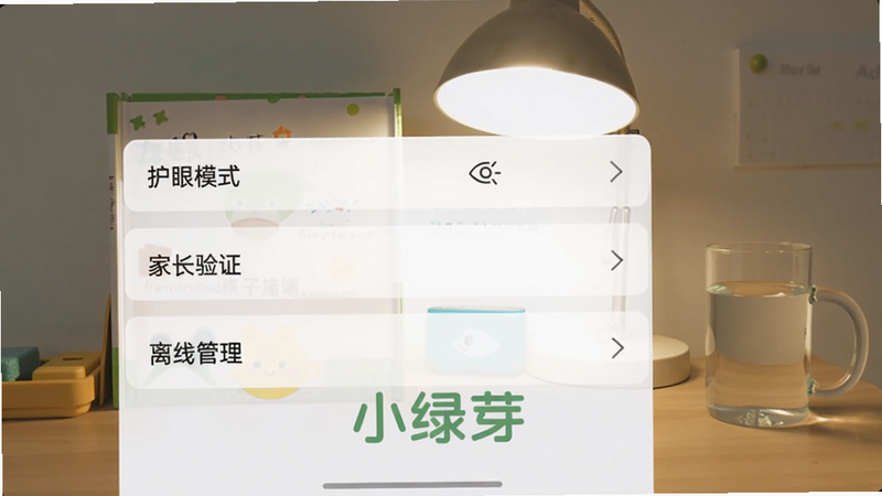 一张手机横屏截图,显示小绿芽孩子端的设置界面,有“护眼模式”“家长验证”“离线管理”等选项。背景是书桌,旁边有台灯和水杯。整体画面清晰,布局规整,色彩柔和。