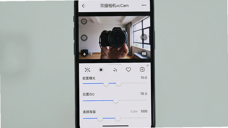 һ��˫�����xcCam�������������չ��ܵĽ����ͼ������Ϊ�ֻ������������棬�ϰ벿����ʾǰ��˫���ʵʱȡ�����棬�°벿��Ϊ���Ų������飬�ֱ��ע��ǰ���ع⡱������ISO�������յȼ�����������������Ƽ��ֱ�ۣ���ťͼ������������Ϊǳ��ɫ�����Ϊ��ˬ��APP����չʾͼ������������ϸ�ڵ�λ�����ʸ��壬ͼƬ������С�˫�����xcCam������������ɾ��޶���Ԫ�ء�