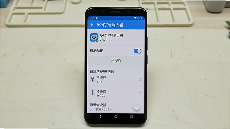 主体为一部安卓手机屏幕,显示“多档字号调大器”的设置页面,其中“辅助功能”开关处于开启状态,下方有“已授权”绿色字样。布局为手机居中,背景为浅色工作台。排版设置项清晰可见,开关为蓝色。风格为真实截图风格,带圆角边框。细节包括“已授权”图标、应用名称和版本号。画质为高清,干净,无多余元素。
