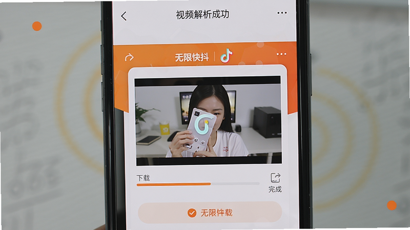 手机屏幕展示“无限快抖”应用内视频解析成功页面,视频画面中央显示无水印的清晰图像,界面有下载进度条与完成提示,背景为浅灰色与橙色点缀,整体风格简洁实用,突出下载功能的便捷与高效,画质干净无多余元素