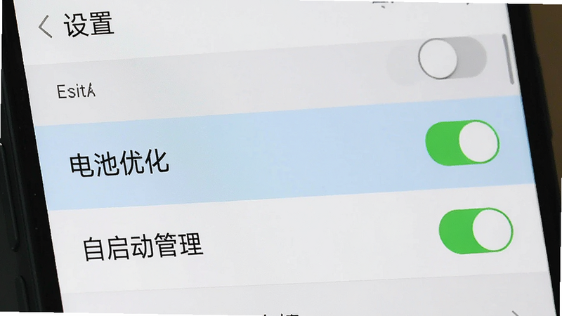 主体为手机设置界面截图,布局为列表式,高亮显示“电池优化”与“自启动管理”选项,排版清晰,风格为系统原生UI,细节为开关按钮状态,画质清晰,干净无水印,文字“设置”与“东潮出行”可见