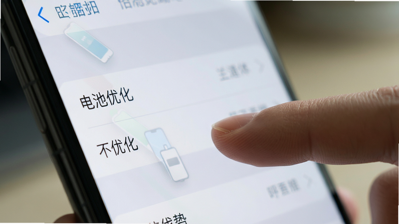 展示手机设置界面的特写,聚焦于“电池优化”选项,手指正点击“不优化”,背景虚化,风格写实,细节清晰,画质高,无其他干扰元素