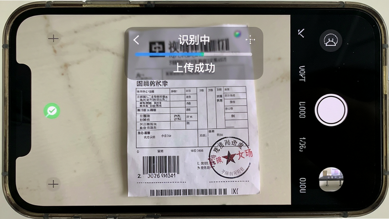 主体为手机拍照界面,相机取景框内显示一张纸质物流回单,上方覆盖半透明UI层,显示