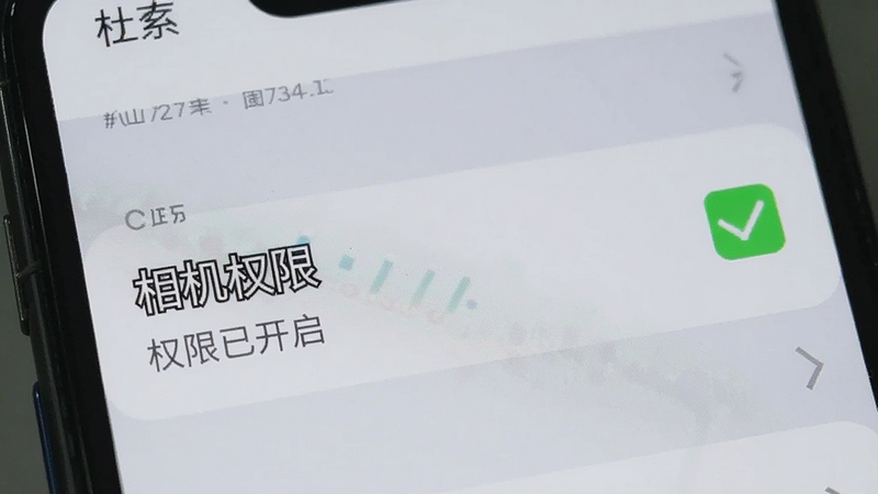 手机屏幕显示一个设置界面,其中“相机权限”选项被勾选为绿色,下方有文字“权限已开启”,背景是浅灰色的设置列表,风格简洁明了,画质清晰,无其他干扰元素