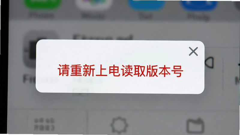 主体为手机屏幕显示错误提示对话框,红色警告文字'请重新上电读取版本号',背景为灰色模糊界面,布局居中,排版紧凑,风格为软件报错界面,细节包含关闭按钮图标,画质清晰,干净,无多余元素