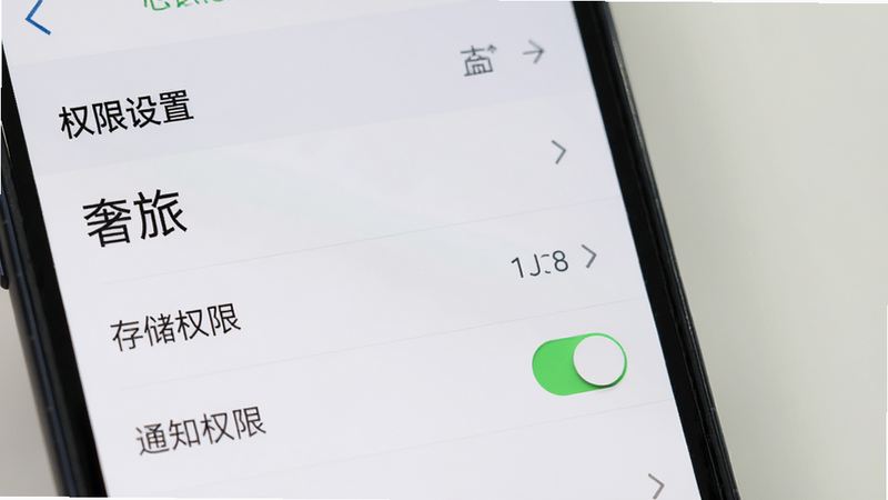 主体为手机设置界面的特写,布局聚焦于“应用管理”中的“奢旅”选项,排版为列表形式,风格扁平化,细节显示“存储权限”、“通知权限”开关状态,画质清晰,干净,无背景杂乱元素,文字标注“权限设置”