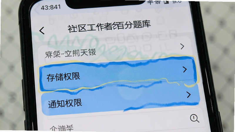 一部安卓手机显示“社区工作者百分题库”的设置界面,重点高亮显示“存储权限”和“通知权限”选项,界面清晰,操作指引明确,写实风格,光线均匀,高清细节