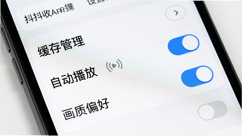 主体为抖抖收APP的设置界面特写,屏幕显示“缓存管理”、“自动播放”、“画质偏好”等选项,开关按钮清晰可见,背景为白色,文字为黑色,布局整齐,风格简洁,细节清晰,画质高清,干净无多余元素